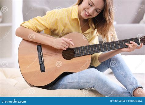 Young Woman Playing Acoustic Guitar Stock Photo - Image of indoors, background: 138158456