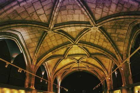 the inside of an old cathedral with vaulted ceilings and stone arches, lit by lights