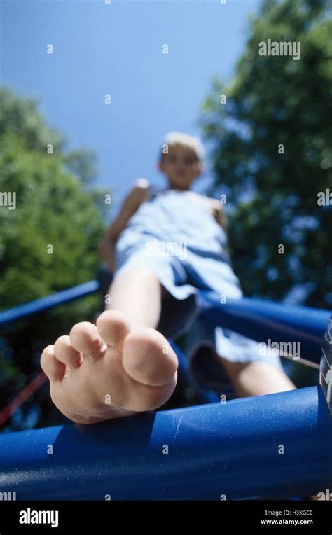 Climbing frame, boy, barefoot, from below, very close, summer ...