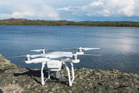 The drone copter with digital camera ready to flying on lake background ...