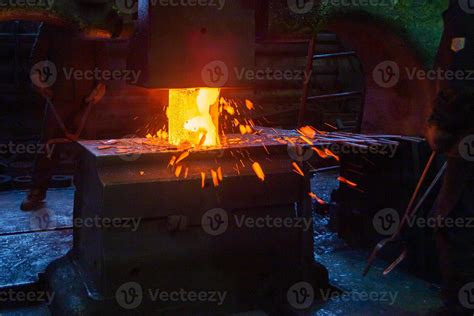 close-up picture of hot steel manual forging process with big mechanical hammer machine 12632672 ...