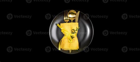 Xmas table setting banner with golden cutlery set on round black plate in center of black ...