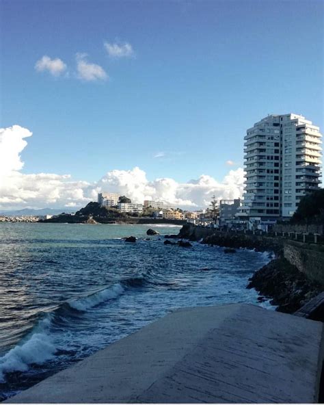 the water is blue and choppy with buildings in the backgrouds on either ...