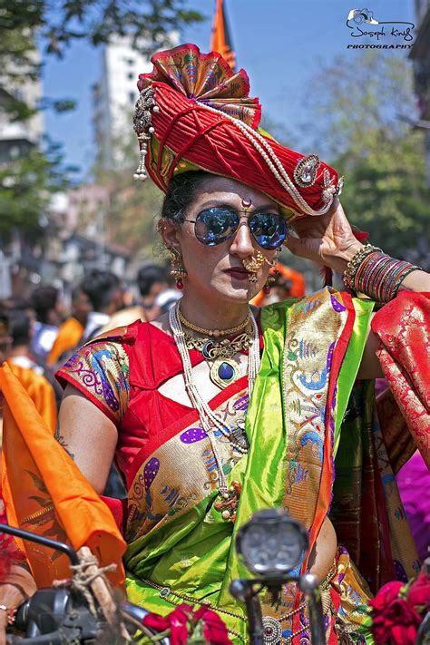 a woman dressed in colorful clothing standing next to a motorcycle