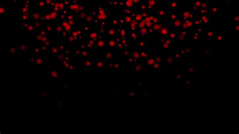 RED particles glowing on the black background. Black background with light particles across the ...