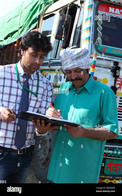 Executive taking signature of a truck driver Stock Photo - Alamy