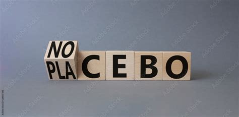 Nocebo vs Placebo symbol. Turned wooden cubes with words Placebo and Nocebo. Beautiful grey ...