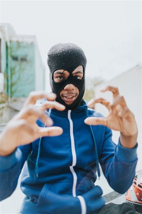 Man in Blue and Black Nike Zip Up Hoodie Covering His Face With His Hand · Free Stock Photo