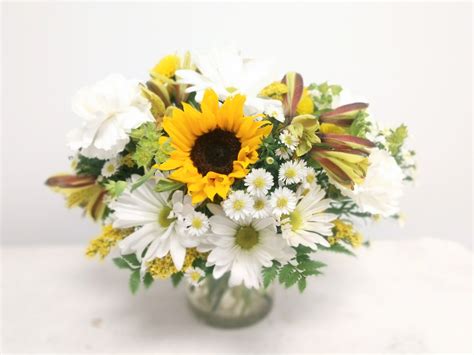 This arrangement is made from miniature sunflowers, yellow alstroemeria, white daisy, yellow ...