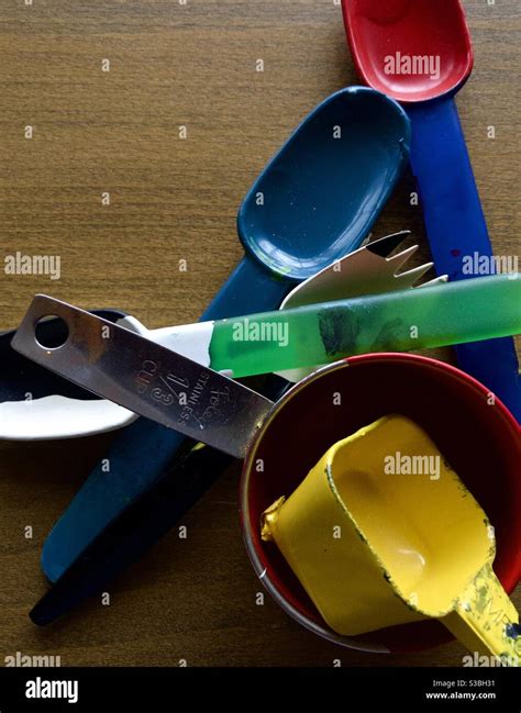 Used paint scoops on wooden drafting table Stock Photo - Alamy