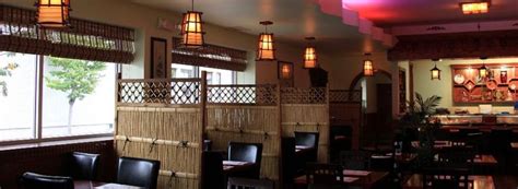 the interior of a restaurant with wooden tables and black leather ...