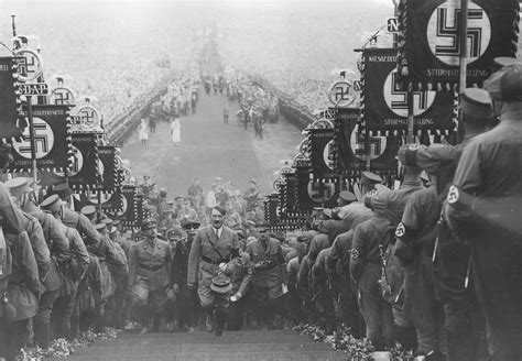 Hitler at the 1935 Nuremberg Rally, walking up the steps to the podium from where he will make ...