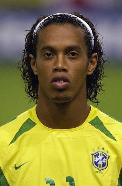 a soccer player with dreadlocks on his head is looking at the camera while wearing a yellow shirt