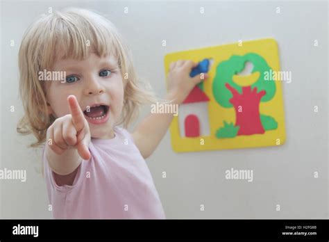 Happy little girl playing with puzzles Stock Photo - Alamy