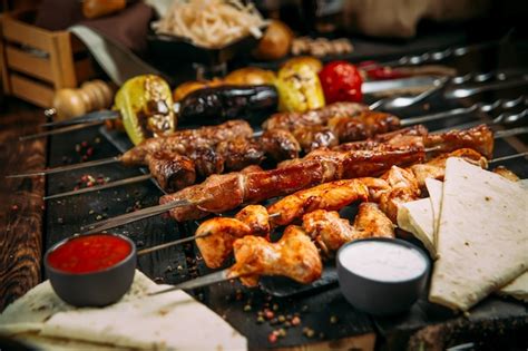 Premium Photo | Appetizing assorted set of kebab skewers on a dark wooden surface