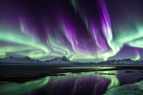 Premium Photo | Northern Lights over snowy mountains. Aurora borealis with starry in the night ...