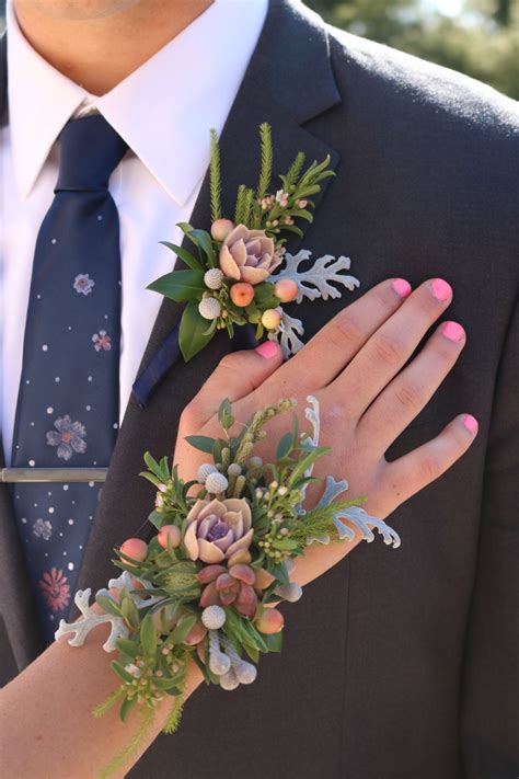 a close up of a person wearing a suit and tie with flowers on his lapel