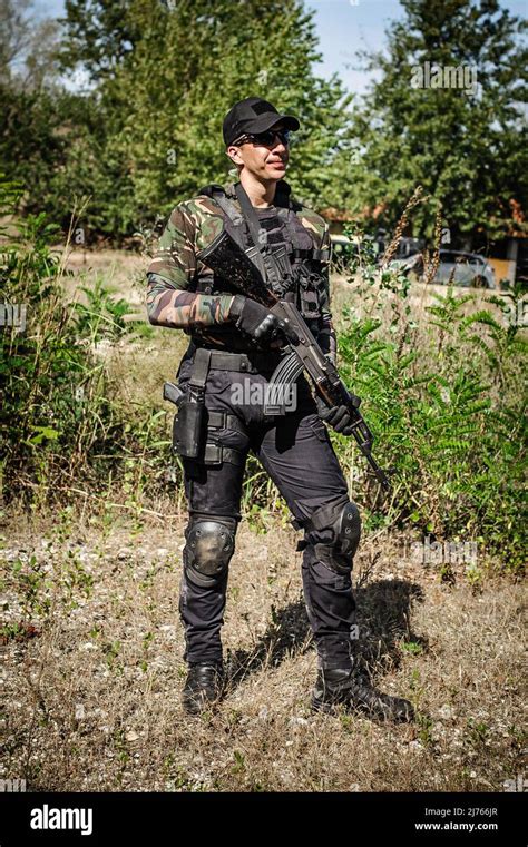 Full armed swat special forces army soldier in combat camouflage uniform. Firearm shooting and ...