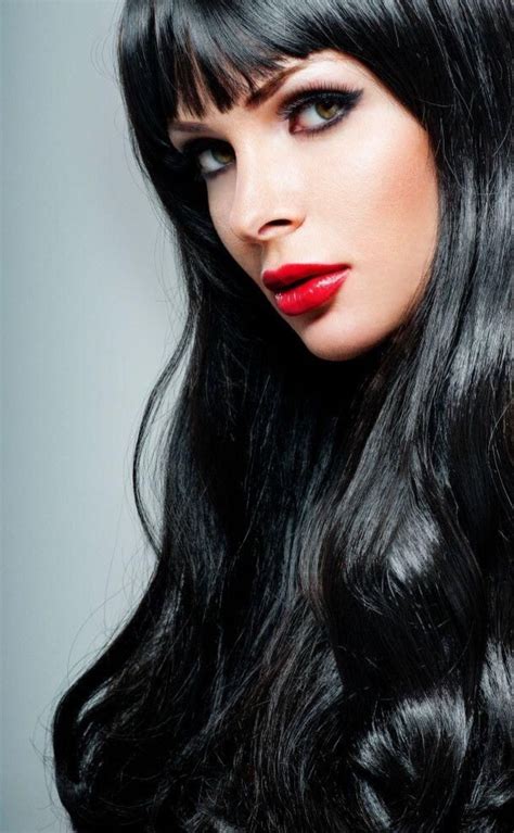 a woman with long black hair and red lipstick