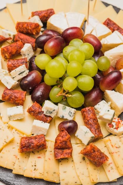 Smoked sausages with cheese platter and grapes | Free Photo