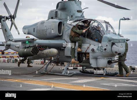 A Marine pilot climbs out from the cockpit of an AH-1Z Super Cobra ...