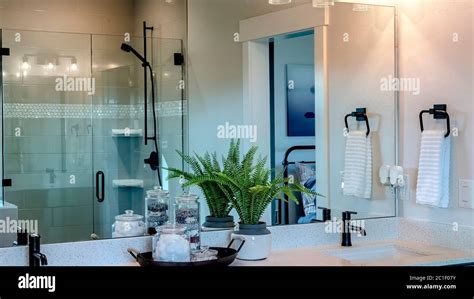 Panorama crop Bathroom with two sinks and wall mirror that reflects shower stall and door Stock ...