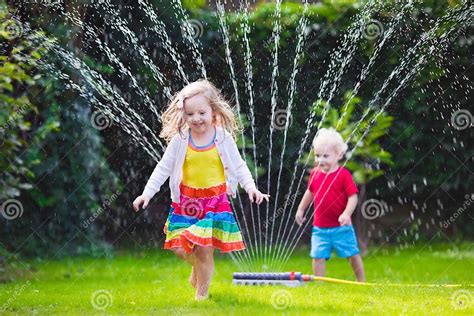 Kids Playing with Garden Sprinkler Stock Photo - Image of jump, home ...