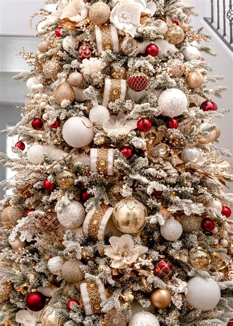 a white christmas tree with red and gold ornaments