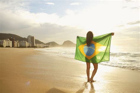 Woman holding Brazilian flag on Copacabana Beach, Rio, Brazil in 2020 ...