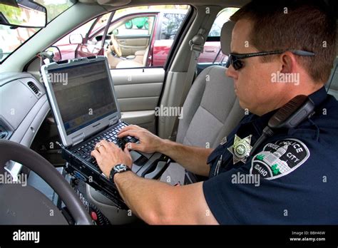 Police officer using a mobile data terminal computer inside a police ...