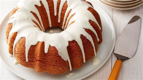 a bundt cake sitting on top of a white plate next to a knife and fork