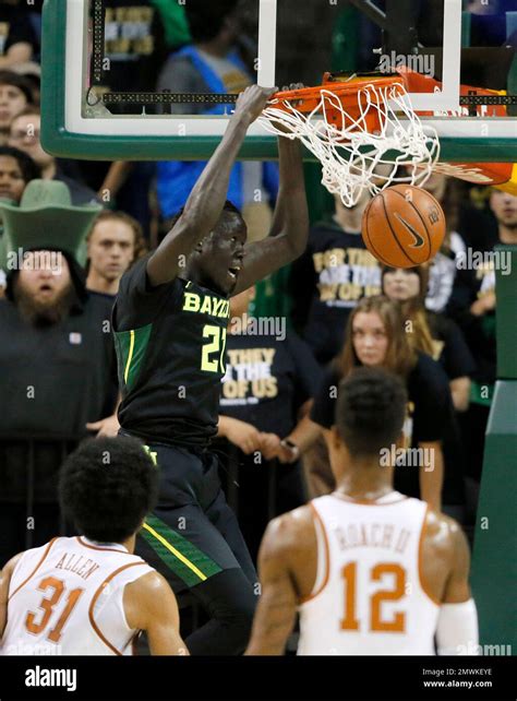 Texas's Jarrett Allen (31) and Kerwin Roach Jr. (12) watch as Baylor's Nuni Omot (21) dunks the ...