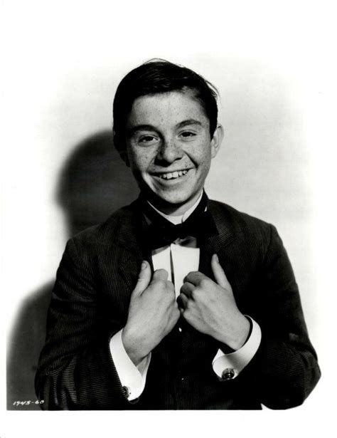 an old photo of a man in a suit and bow tie smiling at the camera