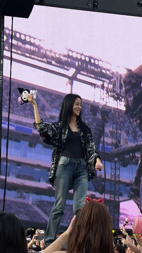 a woman standing on top of a stage holding a stuffed animal