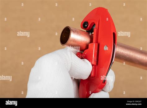 Cutting a copper pipe with a red pipe cutter Stock Photo - Alamy