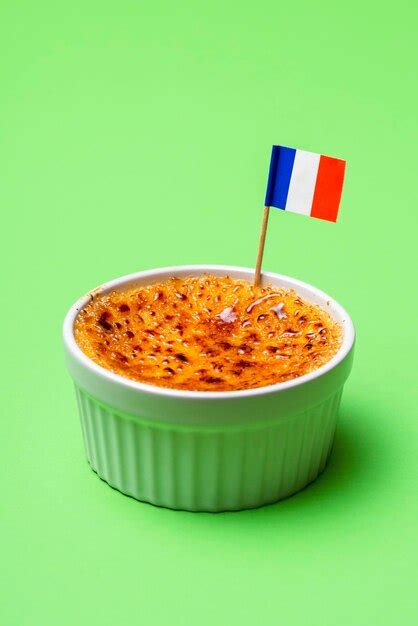 Premium Photo | Ramekins bowl with creme brulee on green background burned cream french recipe