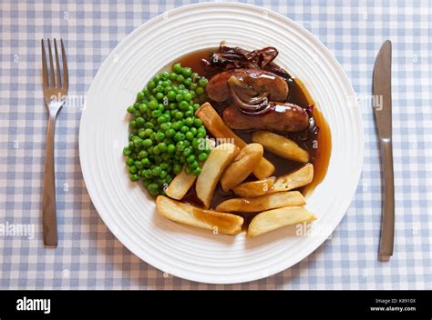 Sausage chips and peas with onion gravy Stock Photo - Alamy