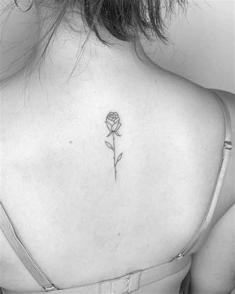 Minimalist rose tattoo on the upper back.