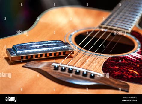 Acoustic guitar with country blues harmonica ready on stage Stock Photo - Alamy