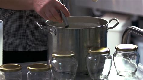 Cheese making process. Cheese maker adding ferment into container with ...