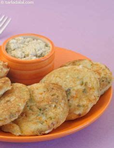 an orange plate topped with fried food next to a fork and bowl filled with dip