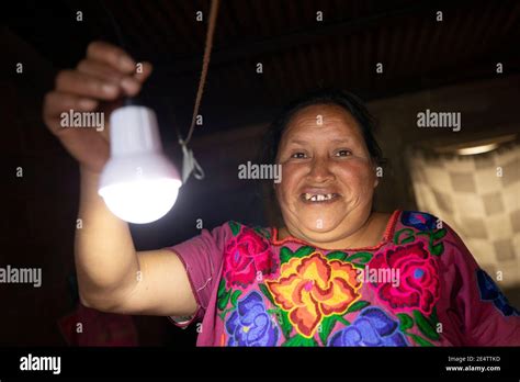 A woman turns her solar-powered lights on for the first time at her home in Cantel, Guatemala ...