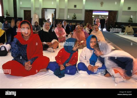 Sikh women and children in prayer hall at Gurdwara or temple, London ...