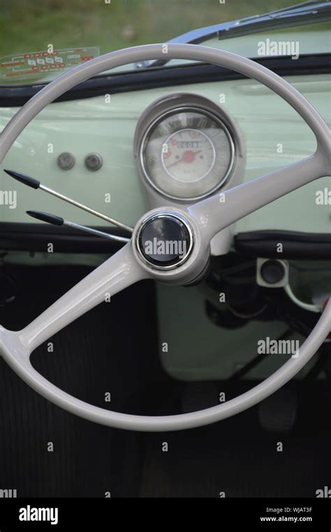 Interior detail of a Fiat Nuova 500 classic car showing the steering wheel speedometer and ...