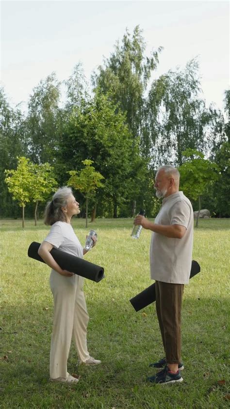 Man and Woman Talking while Holding Yoga Mats · Free Stock Video