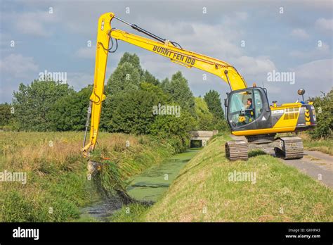 Mechanical digger cleaning out fenland ditch, Cambridgeshire, England ...