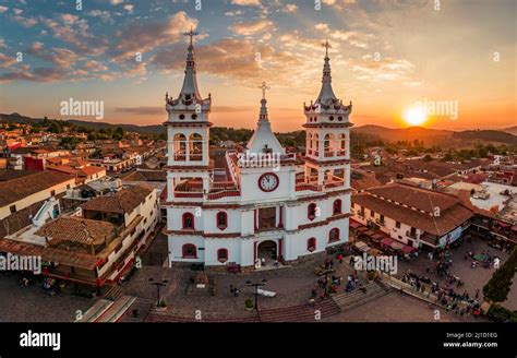 A beautiful Aerial View of San Cristobal Church in Mazamitla, Jalisco, Mexico at sunset orange ...