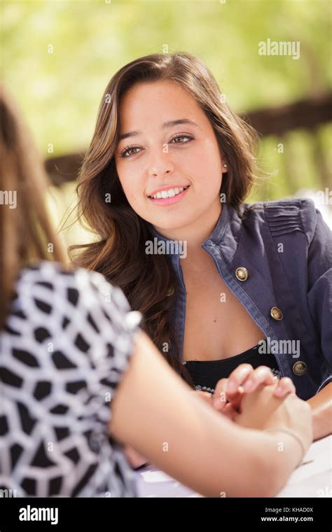 Two Mixed Race Girlfriends Having A Conversation At An Outoor Patio Table Stock Photo - Alamy