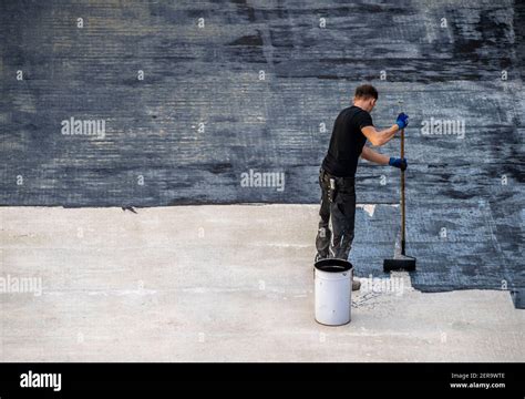 Construction site, application of a bituminous coating on a concrete ceiling, preparation for ...