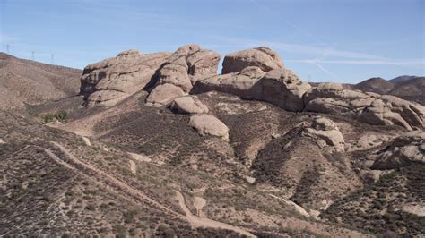 5K stock footage aerial video approach large Mojave Desert rock ...